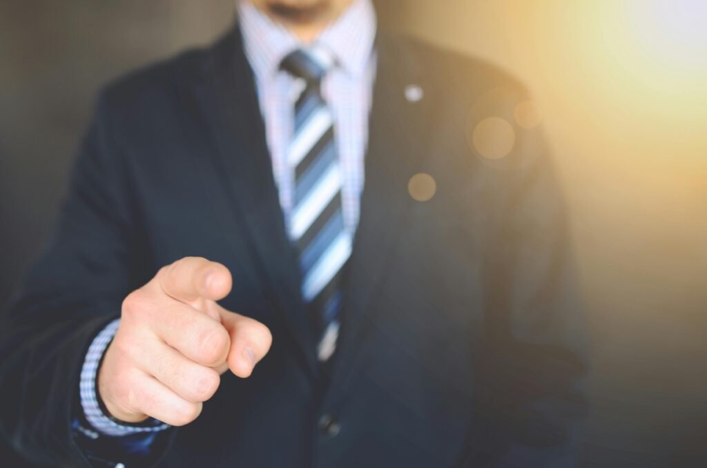 Confident businessman in a suit pointing forward, signifying leadership and focus.